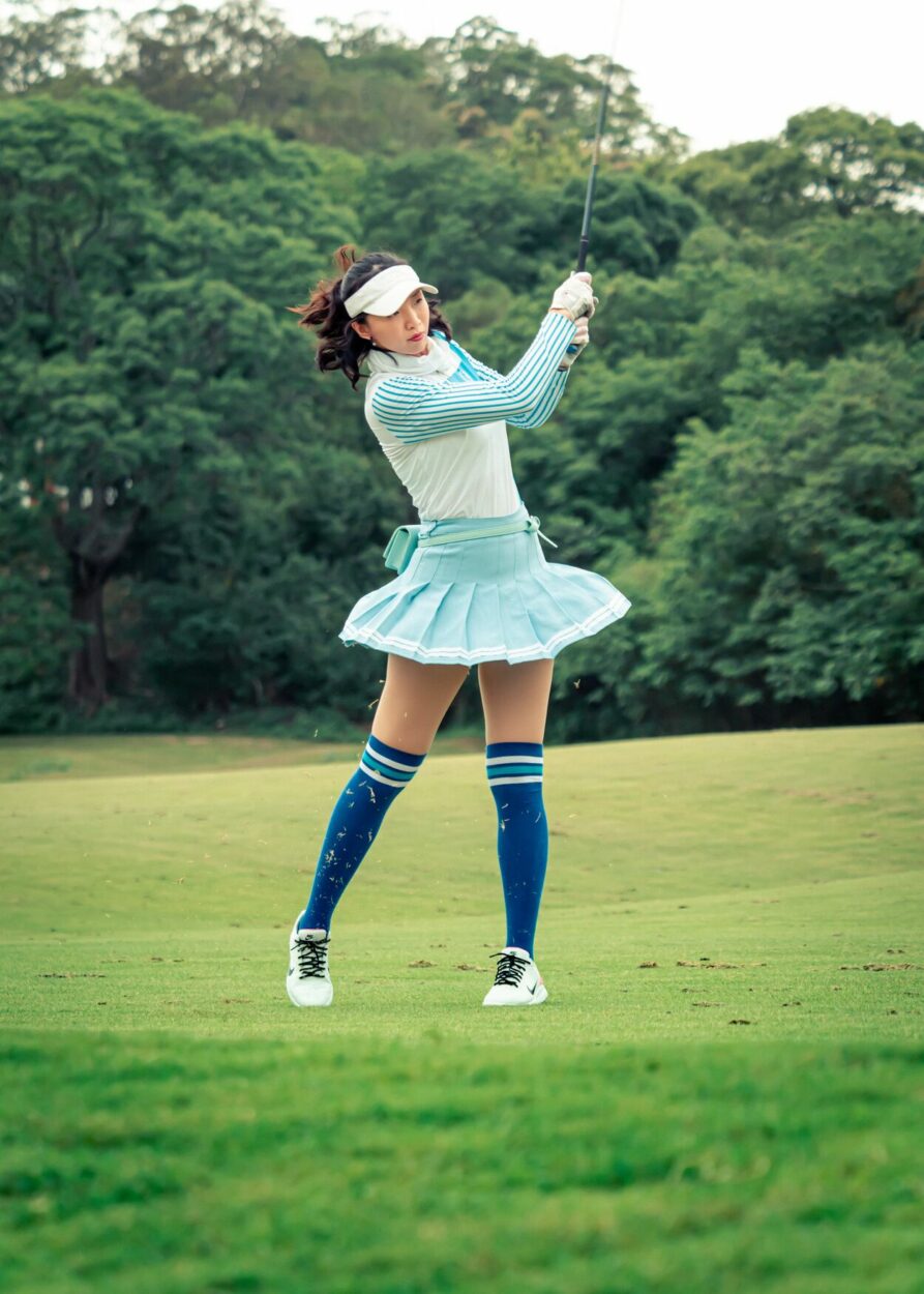 Girl golfer swinging her golf club